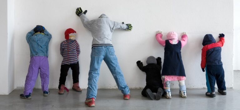Man sieht sechs Skulpturen, die täuschend echt wie Kinder aussehen und mit den Gesichtern zur Wand stehen, an die sie sich wie soeben festgenommene Verbrecher mit ausgestreckten Händen stützen. Es handelt sich um eine Arbeit der Künstler Iris Kettner mit dem Titel GANG, die 2006 in der Ausstellung IRIS KETTNER in der 2yk Galerie, Berlin zu sehen war.
